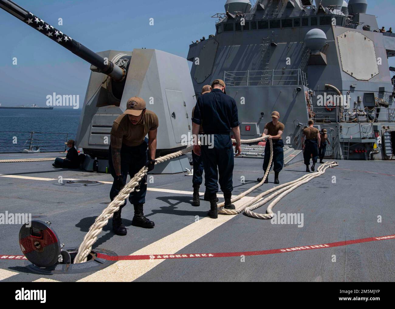 GULF OF OMAN (March 26, 2022) Sailors assigned to the guided-missile destroyer USS Gridley (DDG 101), conduct line handling during a sea and anchor evolution in the Gulf of Oman, March 26. Gridley is deployed to the U.S. 5th Fleet area of operations in support of naval operations to ensure maritime stability and security in the Central Region, connecting the Mediterranean and Pacific through the Western Indian Ocean and three strategic choke points. Stock Photo