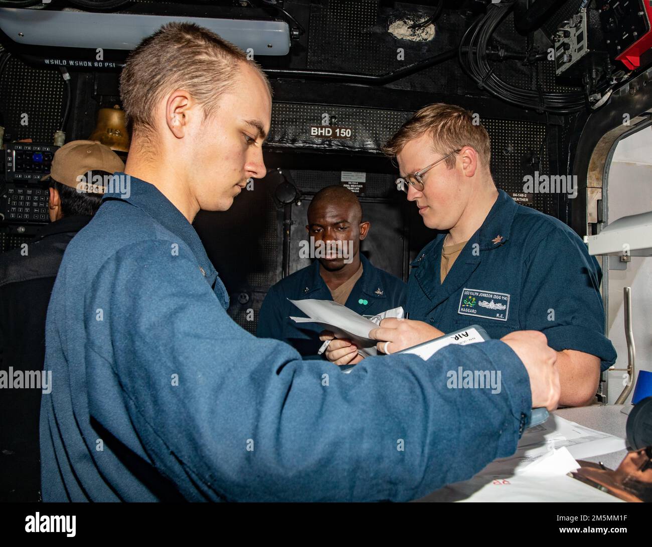 EAST CHINA SEA (March 26,2022) Sailors receive the divisional muster reports during a man overboard drill aboard the Arleigh Burke-class guided-missile destroyer USS Ralph Johnson (DDG 114). Ralph Johnson is forward-deployed to the U.S. 7th Fleet area of operations in support of a free and open Indo-Pacific. Stock Photo