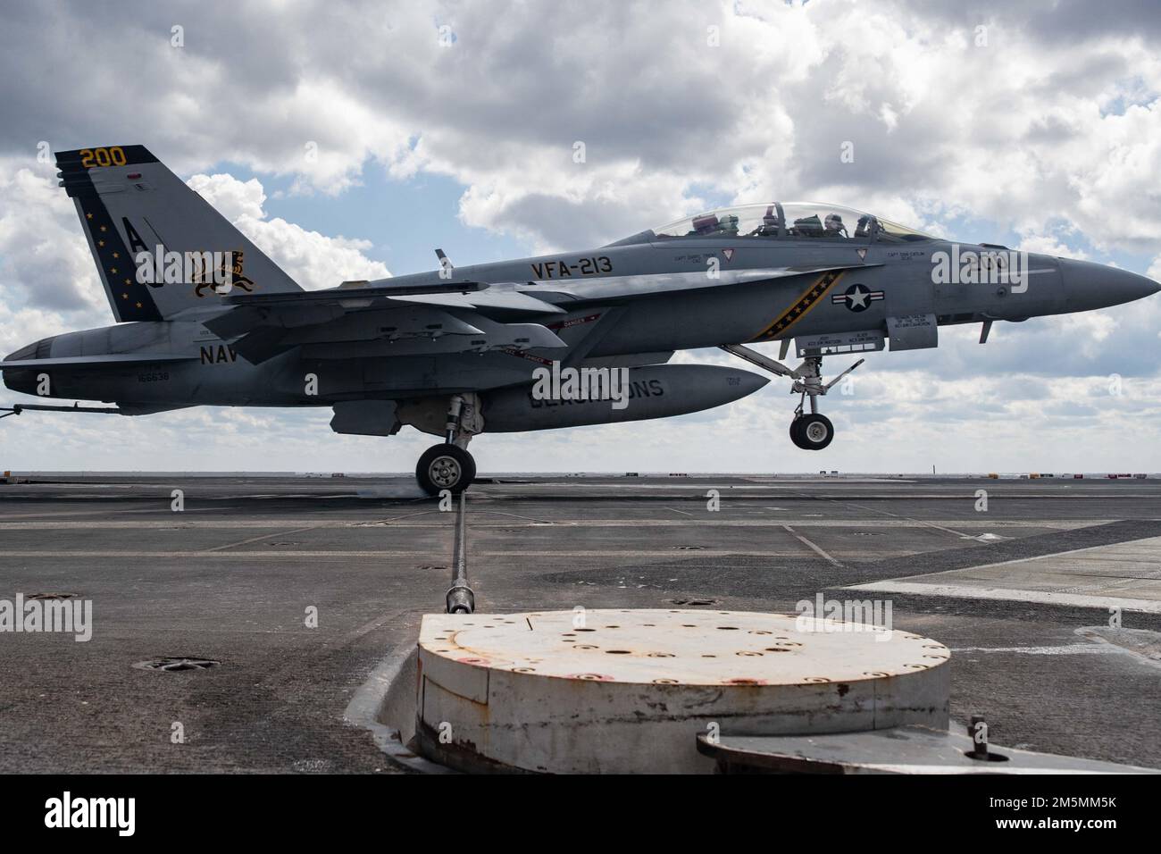 An F/A-18F Super Hornet, attached to the 'Blacklions' of Strike Fighter Squadron (VFA) 213, lands on USS Gerald R. Ford’s (CVN 78) flight deck, March 26, 2022. Ford is underway in the Atlantic Ocean conducting flight deck certification and air wing carrier qualification as part of the ship’s tailored basic phase prior to operational deployment. Stock Photo