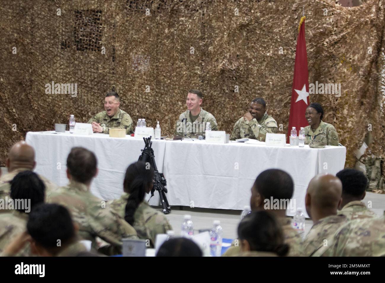 (From left to right) Col. Sean P. Davis, deputy commanding officer, 1st Theater Sustainment Command, Brig. Gen. Lance G. Curtis, commanding general, 3rd Expeditionary Sustainment Command, Master Sgt. Jamel C. Fulks, senior enlisted advisor, 3rd ESC, and Col. Fenicia L. Jackson, chief of staff, 3rd ESC, laugh during a tactical dining-in at Camp Arifjan, Kuwait, Mar. 26, 2022. Curtis hosted the event to uphold U.S. military customs and traditions, foster camaraderie and esprit de corps, and acknowledge the unit’s accomplishments during its deployment in support of 1st TSC. Stock Photo
