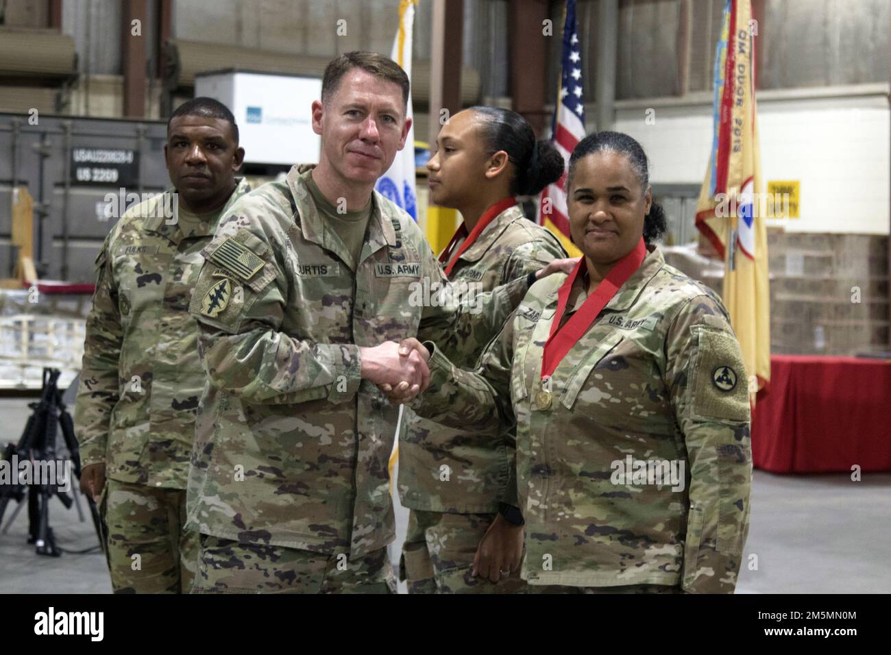 Brig. Gen. Lance G. Curtis, commanding general, 3rd Expeditionary Sustainment Command, shakes hands with Sgt. 1st Class Ana M. Zapata during a tactical dining-in at Camp Arifjan, Kuwait, Mar. 26, 2022. Curtis presented the Ordnance Order of Samuel Sharpe award to Zapata in recognition of her contributions to the U.S. Army Ordnance Corps. Stock Photo