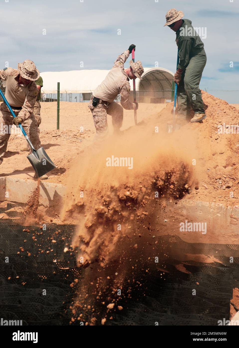 U.S. Marines assigned to Aviation Ground Support, Marine Aviation Weapons and Tactics Squadron One (MAWTS-1), shovel gravel during an airfield damage repair (ADR) exercise at Cannon Air Defense Complex, in Yuma, Arizona, March 26, 2022.  WTI is a seven-week training event hosted by MAWTS-1, providing standardized advanced tactical training and certification of unit instructor qualifications to support Marine aviation training and readiness, and assists in developing and employing aviation weapons and tactics. Stock Photo