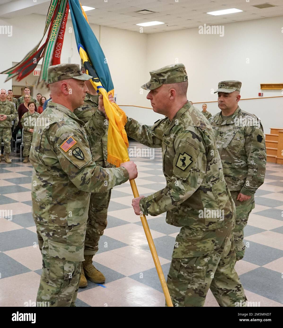(Left to Right) Command Sgt. Maj. Shawn Phillips, command sergeant major of the 55th Maneuver Enhancement Brigade, is passed the brigade colors from Lt. Col. Brad Pierson, incoming commander of the 55th MEB, during the 55th MEB change-of-command ceremony at Fort Indiantown Gap, Pa., on March 26, 2022. Pierson was passed the brigade colors from Maj. Gen. Mark McCormack, commander of the 28th Infantry Division, and charged with commanding the Soldiers of the 55th MEB Stock Photo