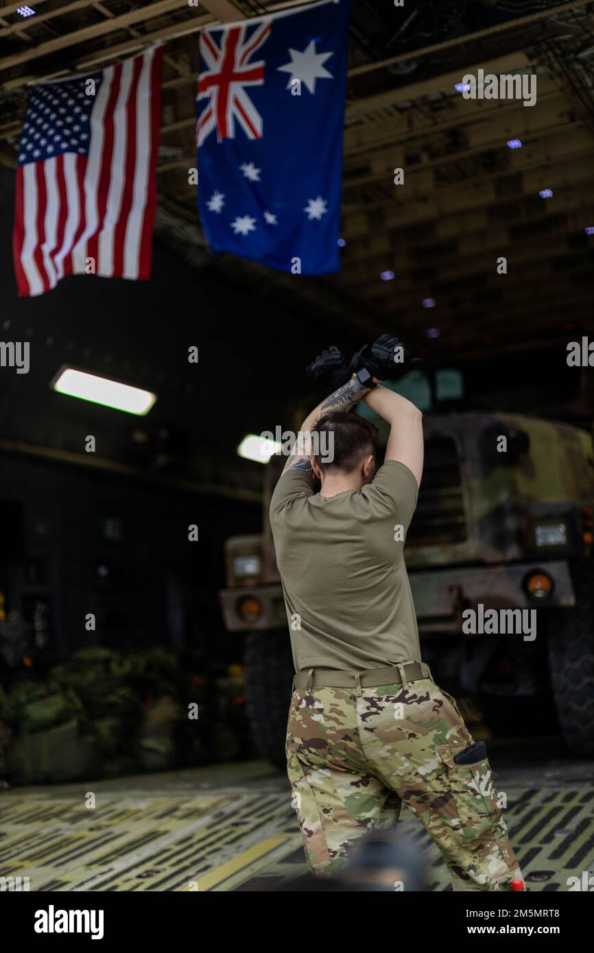 A U.S. Airman with 22nd Airlift Squadron, Air Mobility Command, signals