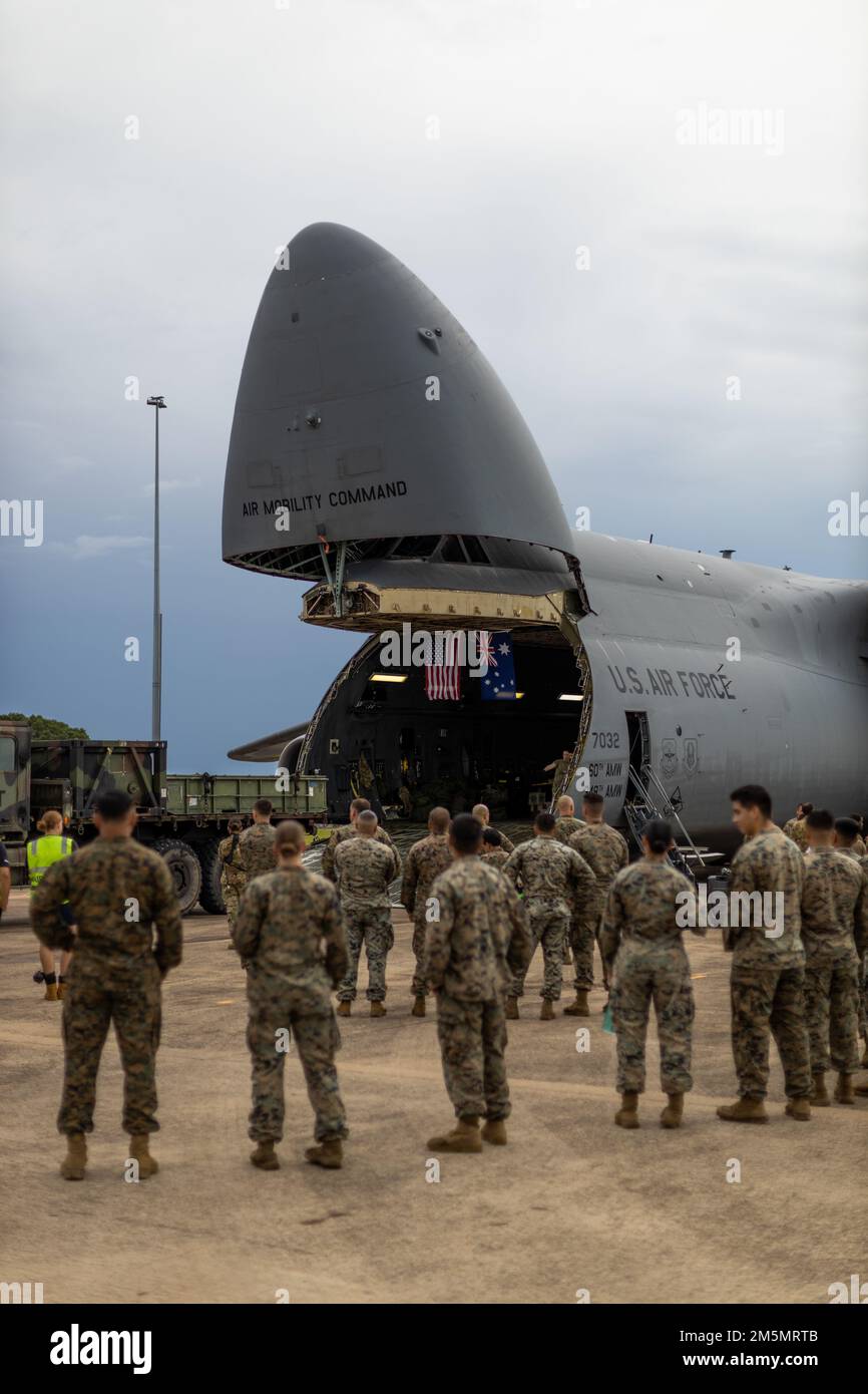 U.S. Marines with Marine Rotational Force-Darwin (MRF-D) 22, observe the loading of a Medium Tactical Vehicle Replacement into a Lockheed C-5M Super Galaxy, operated by the 22nd Airlift Squadron, Air Mobility Command, during a movement of equipment at Royal Australian Air Force Base Darwin, NT, Australia, March 27, 2022. The C-5M will be moving U.S. Marine Corps equipment from Darwin to Okinawa, Japan, an initiative by MRF-D 22, ensuring the equipment is operational to maintain a credible crisis and contingency-ready force that can contribute to a free and open Indo-Pacific region. Stock Photo