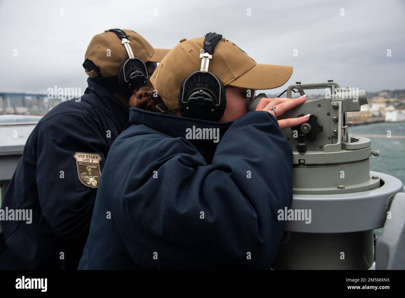 PACIFIC OEAN (March 28, 2022) Quartermaster 3rd Class James Stewart, a native of Hartford, Conn., left, and Quartermaster Seaman Hannah White, a native of Austin, Texas, both assigned to amphibious assault ship USS Essex (LHD 2), use a telescopic alidade during sea and anchor operations aboard Essex, March 28, 2022. Essex is underway conducting routine operations in U.S. 3rd Fleet. Stock Photo