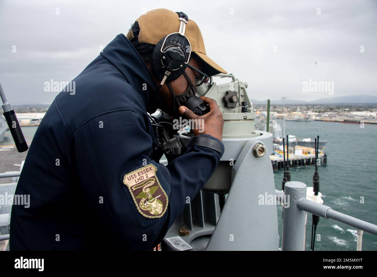 PACIFIC OCEAN (March 28, 2022) Quartermaster 3rd Class James Stewart, a native of Hartford, Conn., assigned to amphibious assault ship USS Essex (LHD 2), uses a telescopic alidade and sound-powered phone during sea and anchor operations aboard Essex, March 28, 2022. Essex is underway conducting routine operations in U.S. 3rd Fleet. Stock Photo