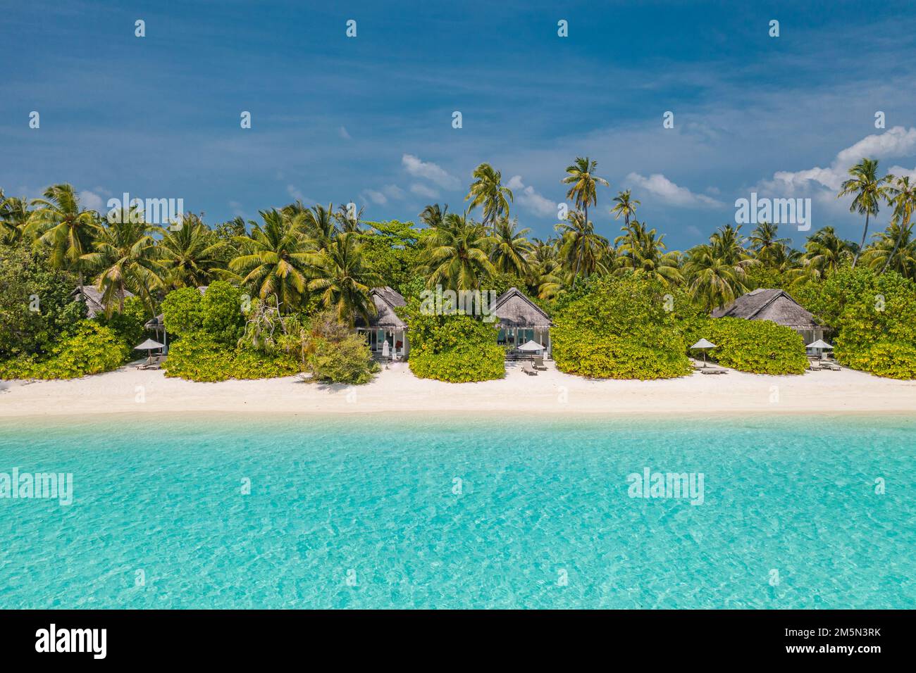 Beautiful atoll and island in Maldives from aerial view. Tranquil tropical landscape and seascape with palm trees on white sandy beach, amazing nature Stock Photo