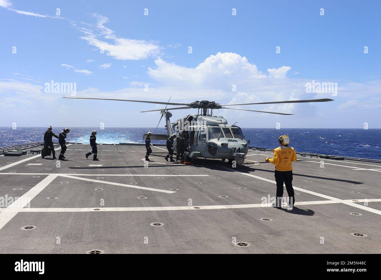 220328-O-NR876-878  PHILLIPPINE SEA (March 28, 2022) – Sailors from the French Navy Floréal-class frigate FS Vendémiaire (F 734) board a helicopter to depart the Independence-variant littoral combat ship USS Charleston (LCS 18). Charleston, part of Destroyer Squadron (DESRON) 7, is on a rotational deployment, operating in the U.S. 7th Fleet area of operations to enhance interoperability with partners and serve as a ready-response force in support of a free and open Indo-Pacific region. Stock Photo