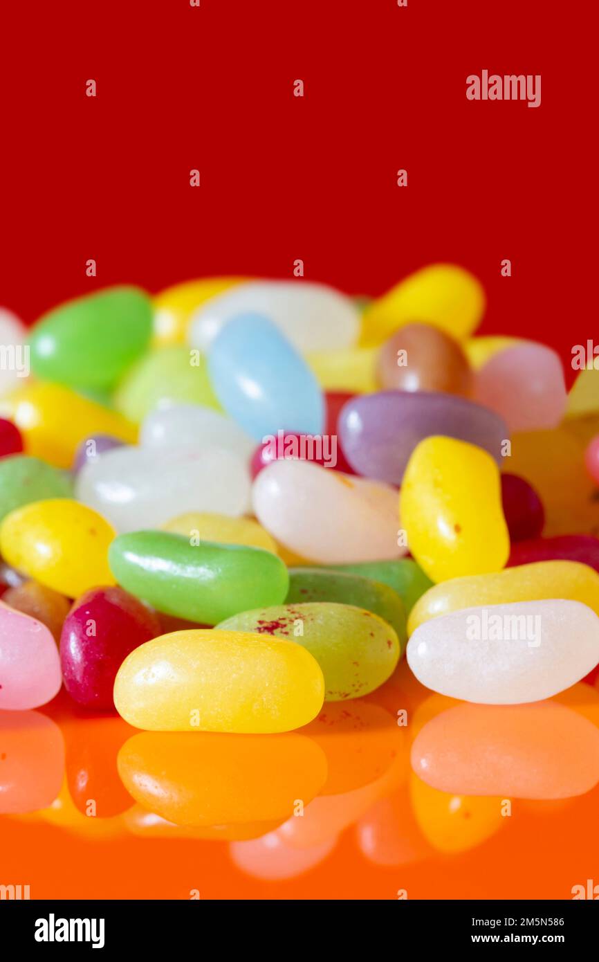 Jelly beans sweets candy piled on an orange background. High sugar
