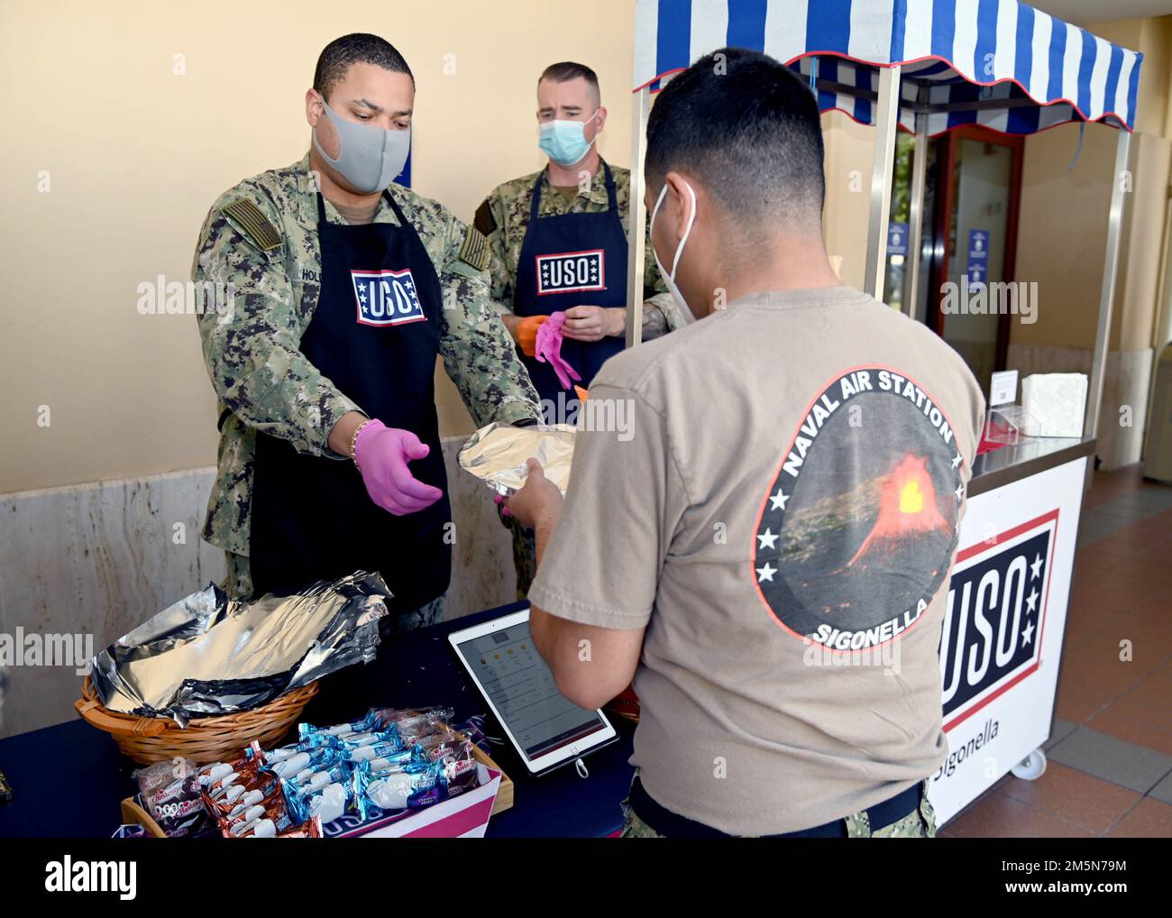 220329-N-OX321-1020 NAVAL AIR STATION SIGONELLA, Italy (March 29, 2022) – Senior Chief Intelligence Specialist Robert Holder from St. Thomas, Virgin Islands, serves lunch at the USO Troop Lunch to help raise awareness for the Chief’s Birthday at Naval Air Station Sigonella on March 29, 2022. NAS Sigonella’s strategic location enables U.S., allied, and partner nation forces to deploy and respond as required, ensuring security and stability in Europe, Africa, and Central Command. Stock Photo