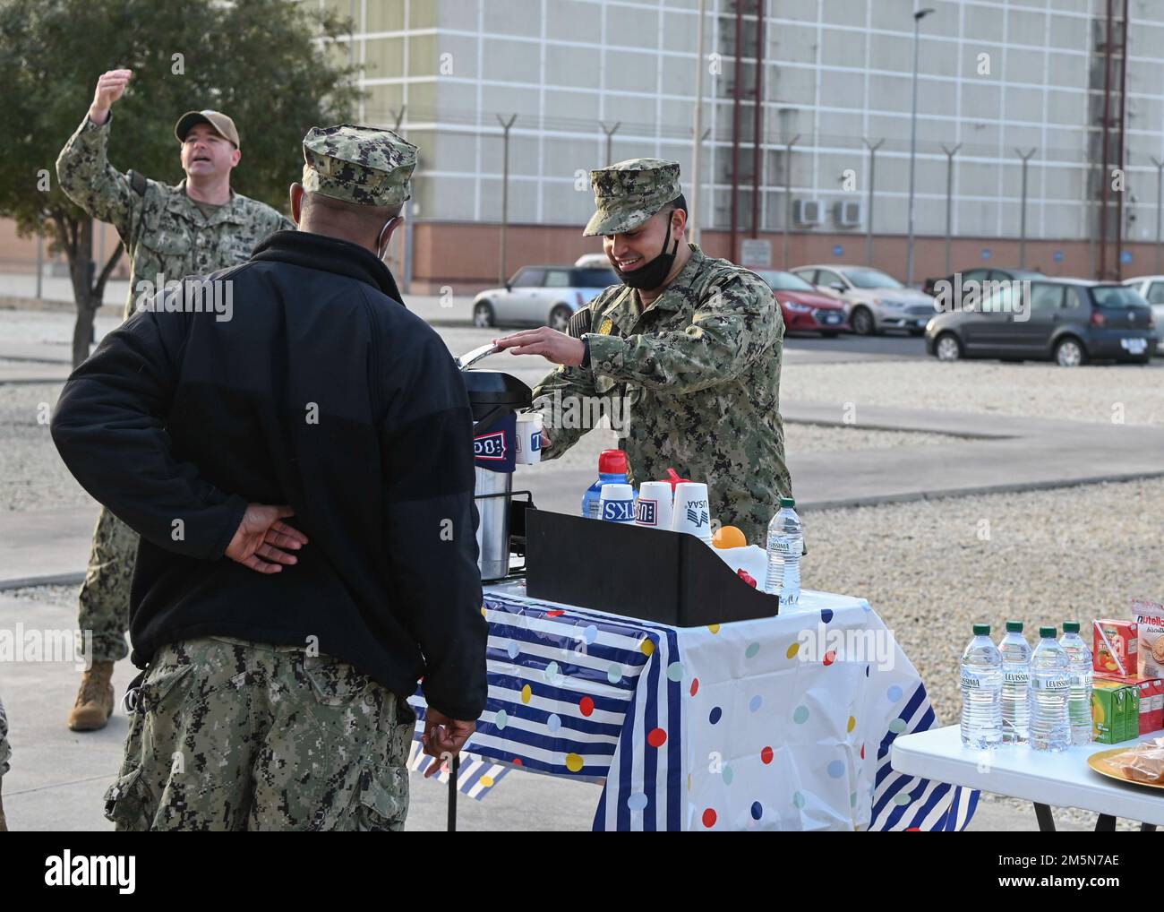 220329-N-GK686-1117 NAVAL AIR STATION SIGONELLA, Italy (Mar. 29, 2022)—Master-at-Arms 1st Class Raul Hernandez receives free coffee from U.S. Navy chiefs in honor of the upcoming Chief’s Birthday on Naval Air Station Sigonella, Mar. 29, 2022. NAS Sigonella’s strategic location enables U.S., allied, and partner nation forces to deploy and respond as required, ensuring security and stability in Europe, Africa and Central Command. Stock Photo