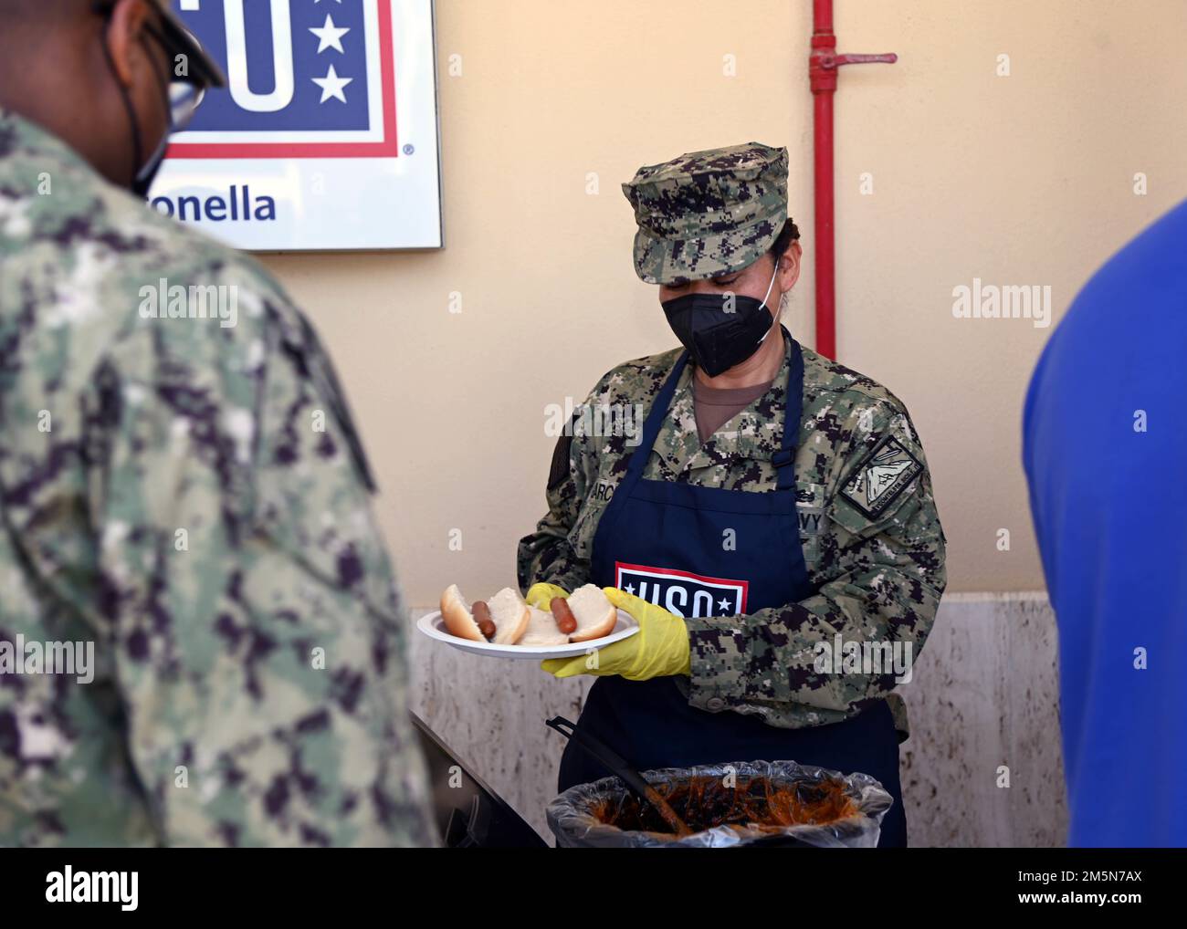 220329-N-OX321-1003 NAVAL AIR STATION SIGONELLA, Italy (March 29, 2022) – Chief Engineman Ofelia Garcia from Houston serves lunch at the USO Troop Lunch to help raise awareness for the Chief’s Birthday at Naval Air Station Sigonella on March 29, 2022. NAS Sigonella’s strategic location enables U.S., allied, and partner nation forces to deploy and respond as required, ensuring security and stability in Europe, Africa, and Central Command. Stock Photo