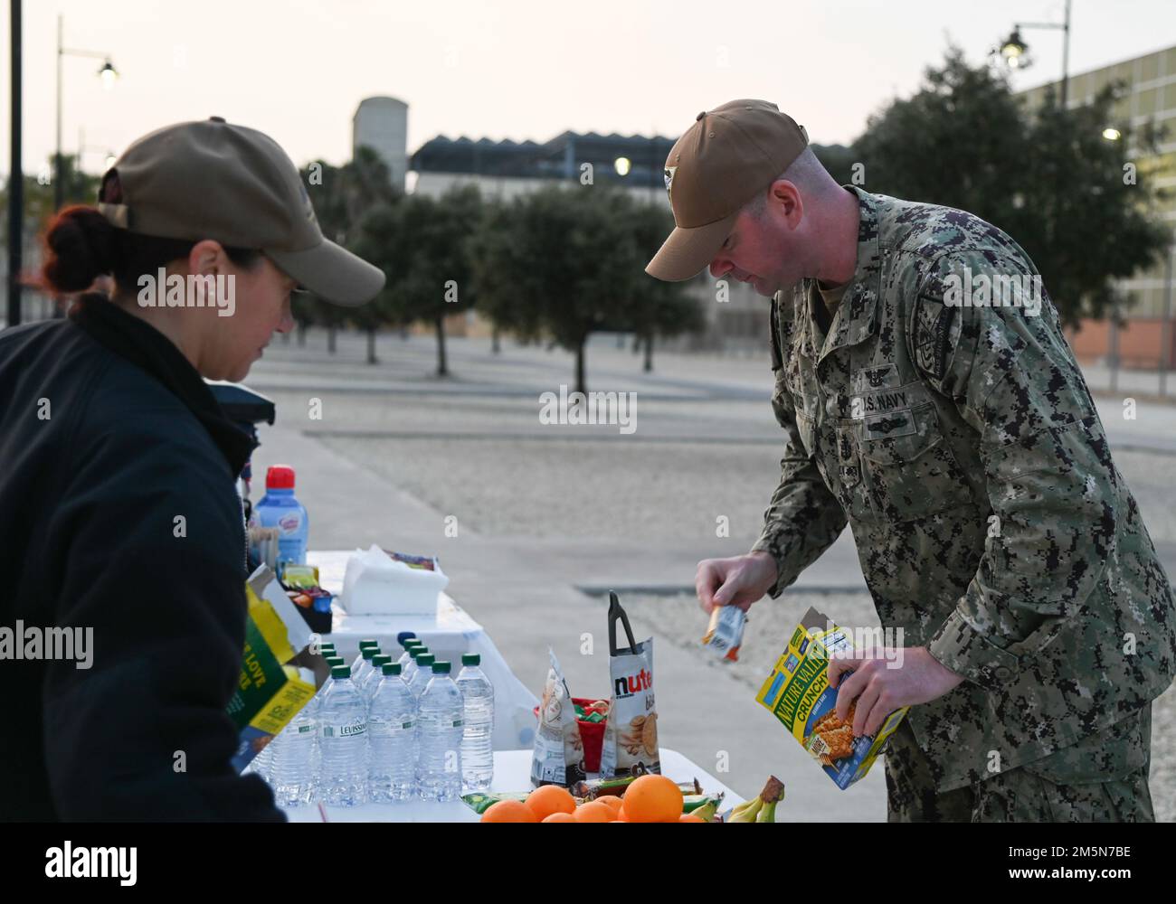 220329-N-GK686-1021 NAVAL AIR STATION SIGONELLA, Italy (Mar. 29, 2022) – Senior Chief Aviation Boatswain’s Mate (Equipment) David Hooker, from Jacksonville, Fla., stocks the food to hand out to service members in honor of the upcoming Chief’s Birthday on Naval Air Station Sigonella, Mar. 29, 2022. NAS Sigonella’s strategic location enables U.S., allied, and partner nation forces to deploy and respond as required, ensuring security and stability in Europe, Africa and Central Command. Stock Photo