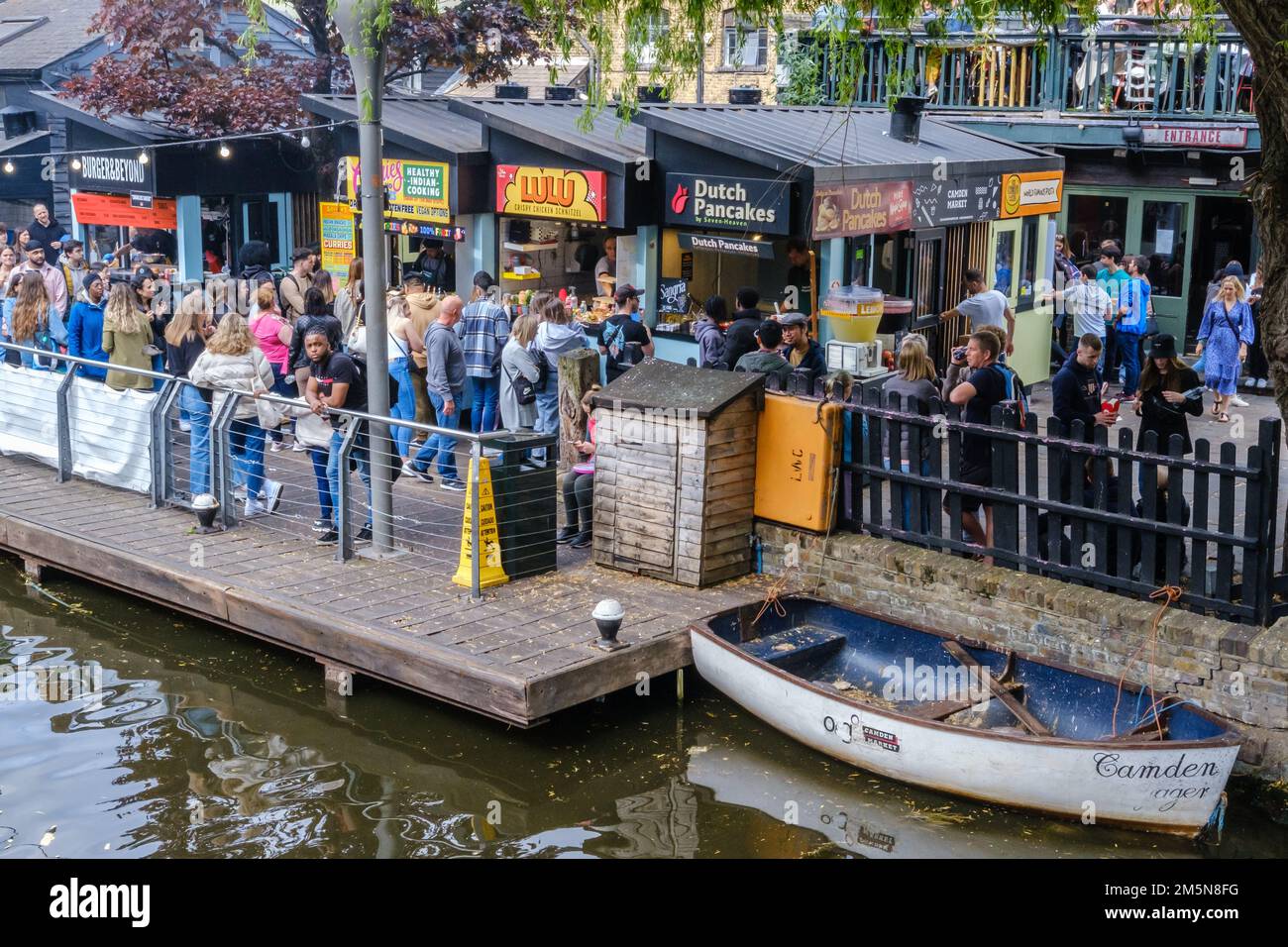 Crowds of people and diverse international fast food stalls at Camden Market, next to Regent’s Canal, Central London, England. Stock Photo