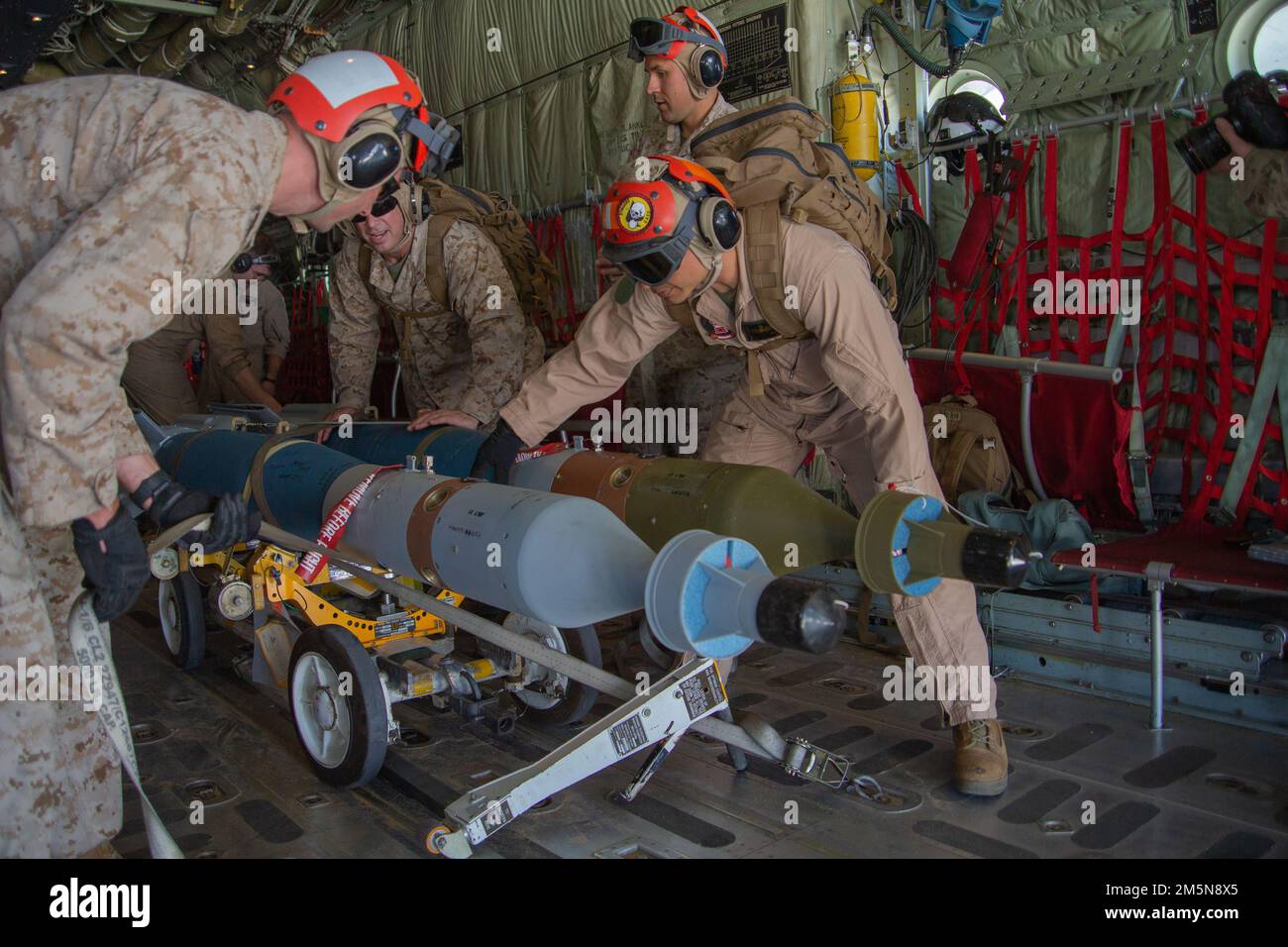 U.S. Marines assigned to Marine Aviation Weapons and Tactics Squadron One (MAWTS-1), secure ordnance inside a KC-130J Hercules during distributed STOVL operations (DSO), in support of Weapons and Tactics Instructor (WTI) course 2-22, at Marine Corps Air Station Yuma, Arizona, March 29, 2022. WTI is a seven-week training event hosted by MAWTS-1, providing standardized advanced tactical training and certification of unit instructor qualifications to support Marine aviation training and readiness, and assists in developing and employing aviation weapons and tactics. Stock Photo
