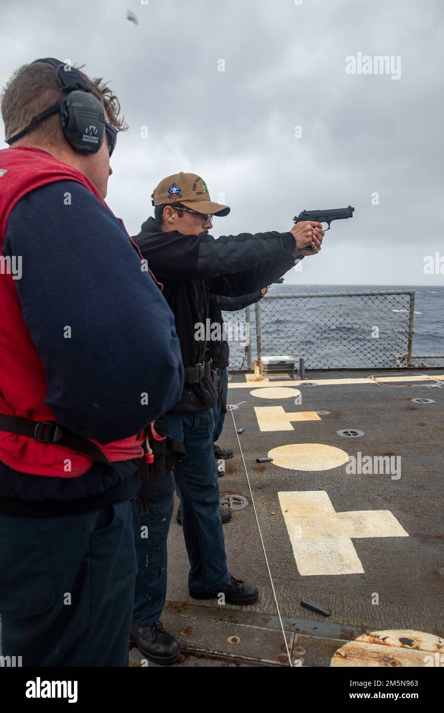 EAST CHINA SEA (March 28,2022) Boatswain’s Mate 3rd Class Adonis Morenco, from San Francisco, shoots a 9mm pistol during a small-arms live-fire qualification aboard the Arleigh Burke-class guided-missile destroyer USS Ralph Johnson (DDG 114). Ralph Johnson is forward-deployed to the U.S. 7th Fleet area of operations in support of a free and open Indo-Pacific. Stock Photo