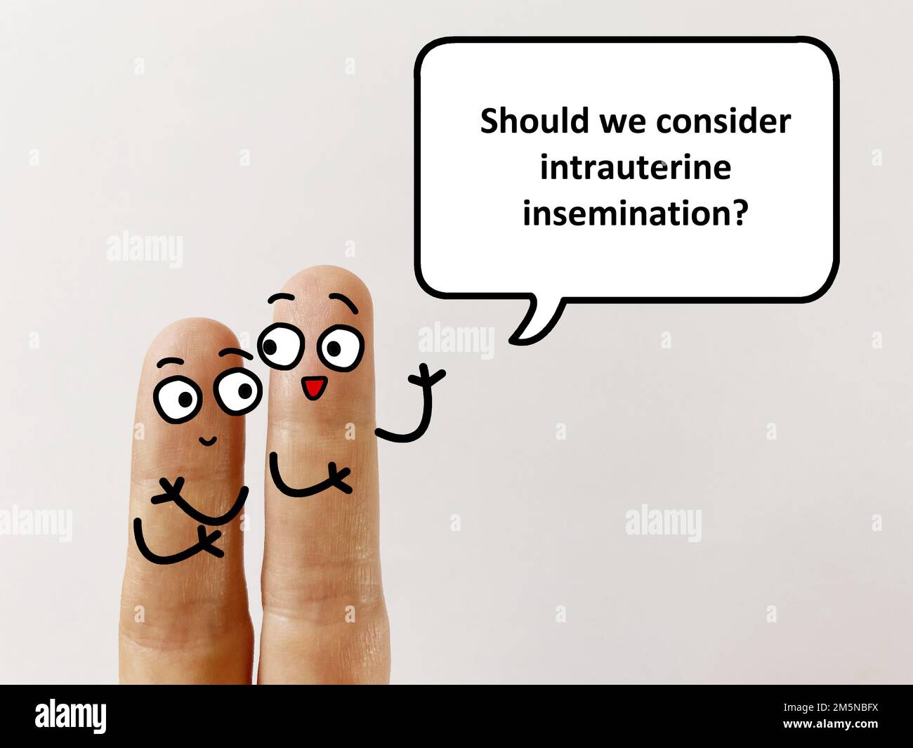 Two fingers are decorated as two person. One of them is asking another if they should consider intrauterine insemination Stock Photo