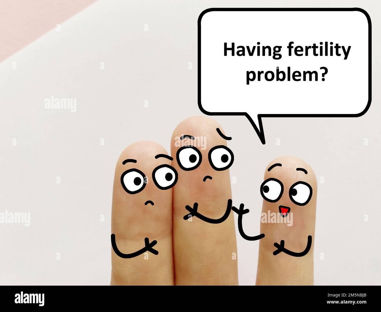 Three fingers are decorated as three person. One of them is asking if they are having fertility problem. Stock Photo