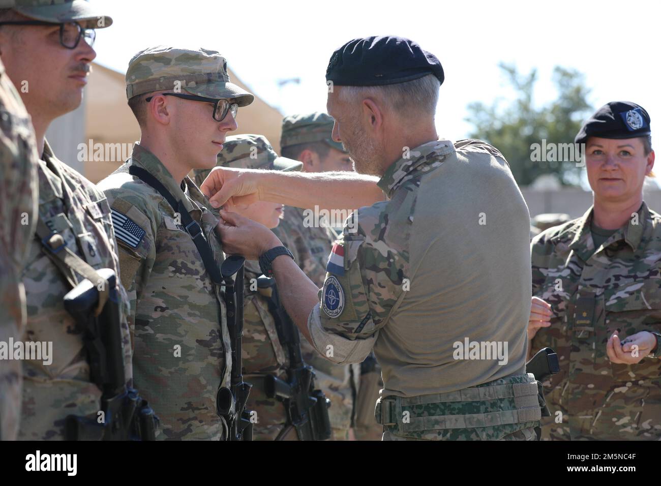 Norwegian Army officers present U.S. Soldiers assigned to Task Force Pioneer, Combined Joint Task Force – Operation Inherent Resolve, with Norwegian Army foot march badges and certificates, March 29, 2022, in Baghdad, Iraq. The Norwegian foot march is a physically challenging test of endurance, physical fitness and mental resilience in which participants are expected to complete an 18.6-mile foot march while carrying a 25-pound ruck within a time standard. Stock Photo