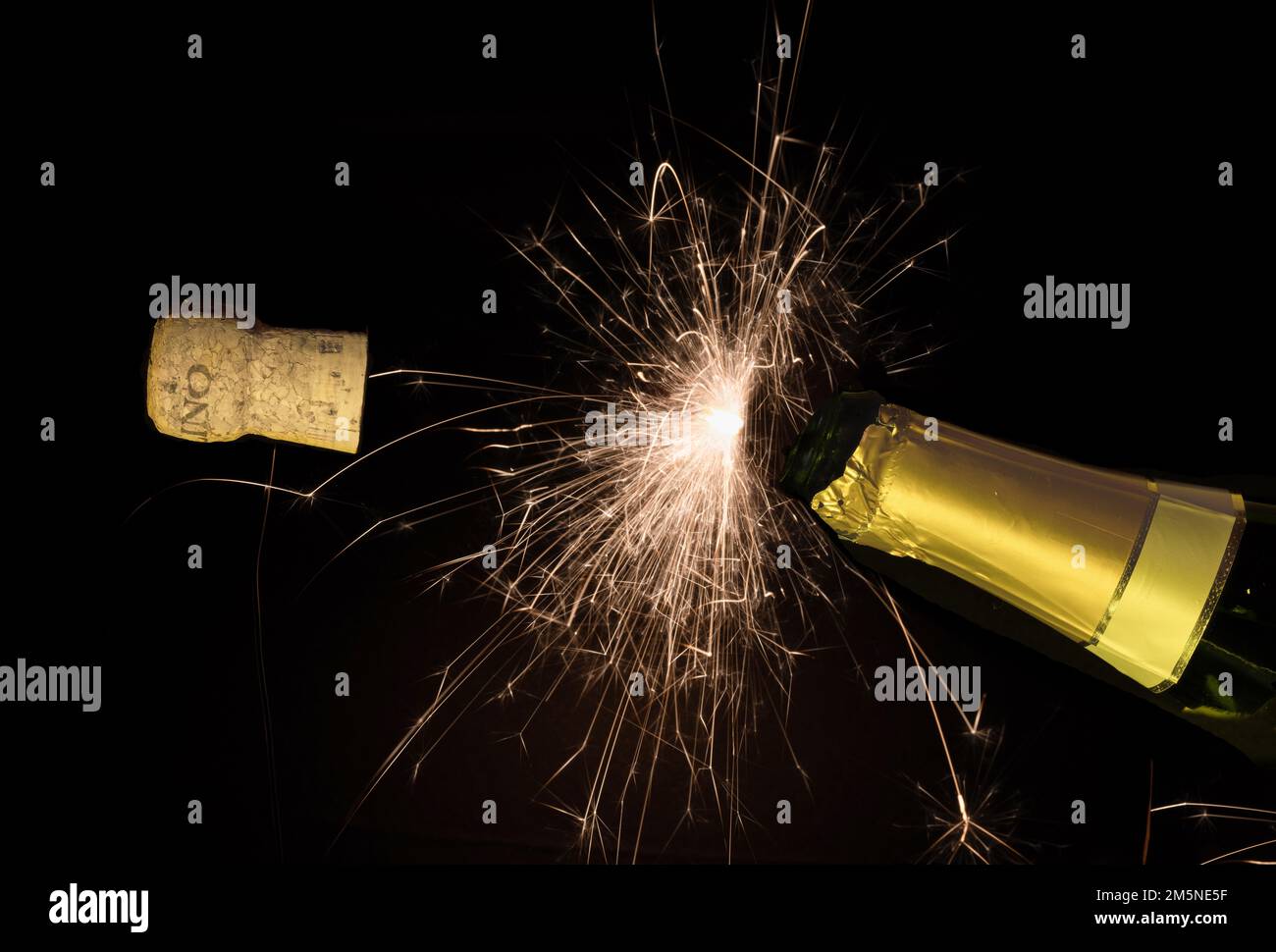 Champagne bottle cork pops on new year's eve Stock Photo