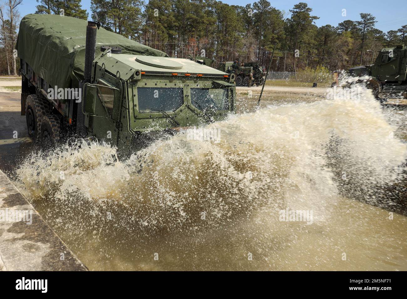 A Medium Tactical Vehicle Replacement with 3rd Landing Support Battalion, Combat Logistics Regiment 3, 3rd Marine Logistics Group, drives through water while conducting a deep water fording training course during exercise Atlantic Dragon at Marine Corps Base Camp Lejeune, North Carolina, Mar. 29, 2022. 3rd LSB is conducting Atlantic Dragon 22 in collaboration with CLR-37, 3rd MLG, and Combat Logistics Battalion 451, CLR-45, 4th MLG, to offload, inspect, and prepare equipment for a diverse array of purposes across the Marine Corps. During the exercise, 3rd LSB is testing capabilities on conduct Stock Photo