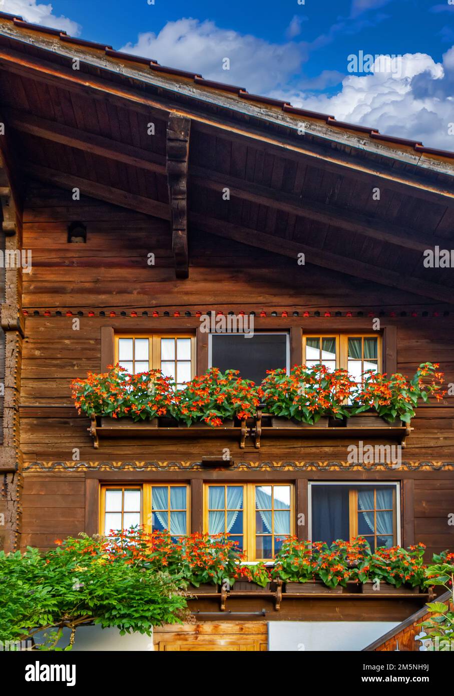 Old wooden house with flowers on the balcony in Switzerland Alps Stock