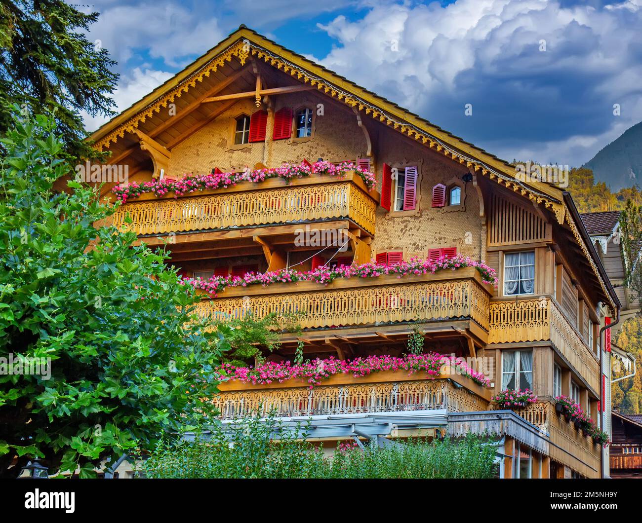 Old wooden house with flowers on the balcony in Switzerland Alps Stock