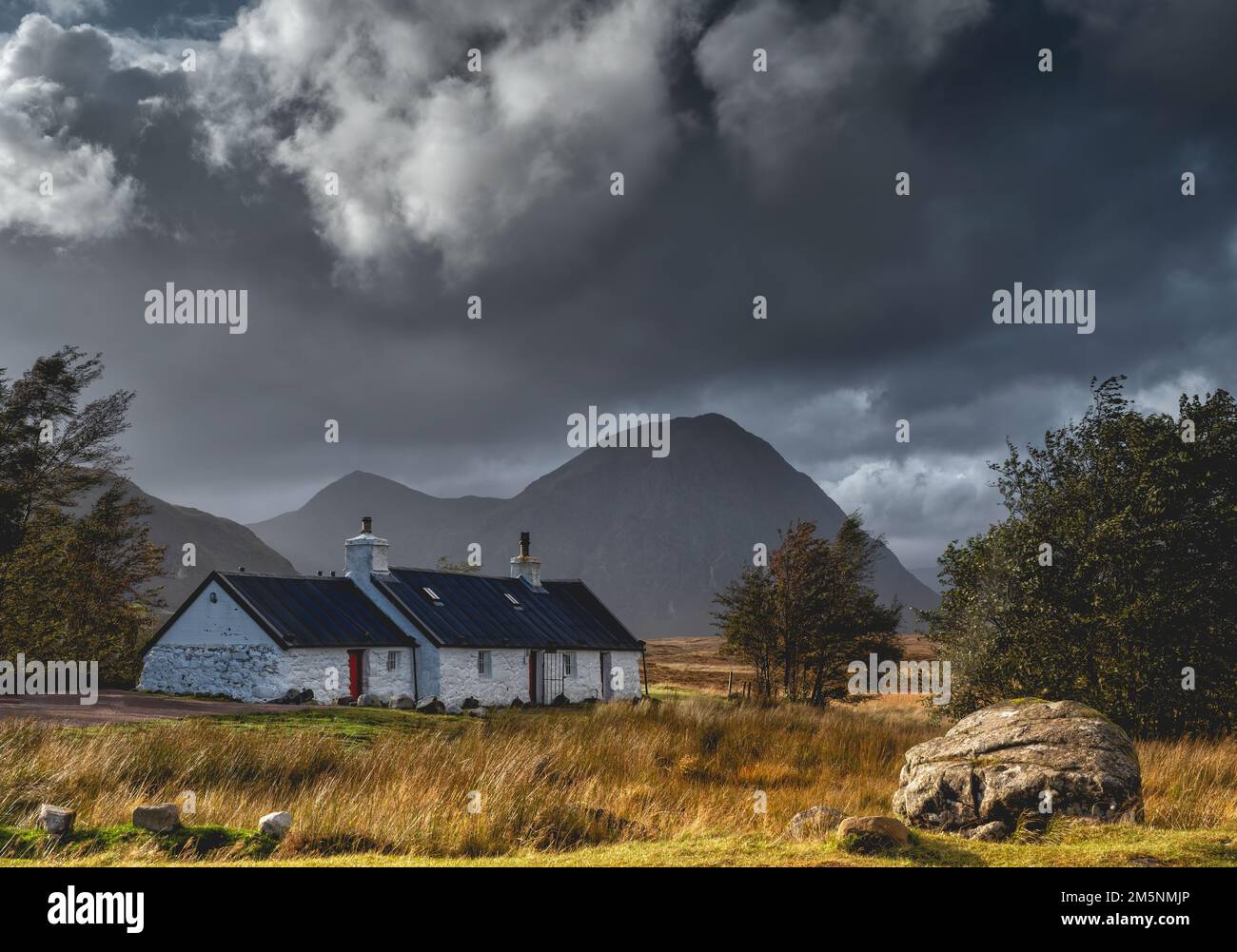 Black rock Cottage in Glencoe in the Scottish Highlands. Rugged scenery and landscapes in the mountains near Loch Ness and Fort William. Stock Photo