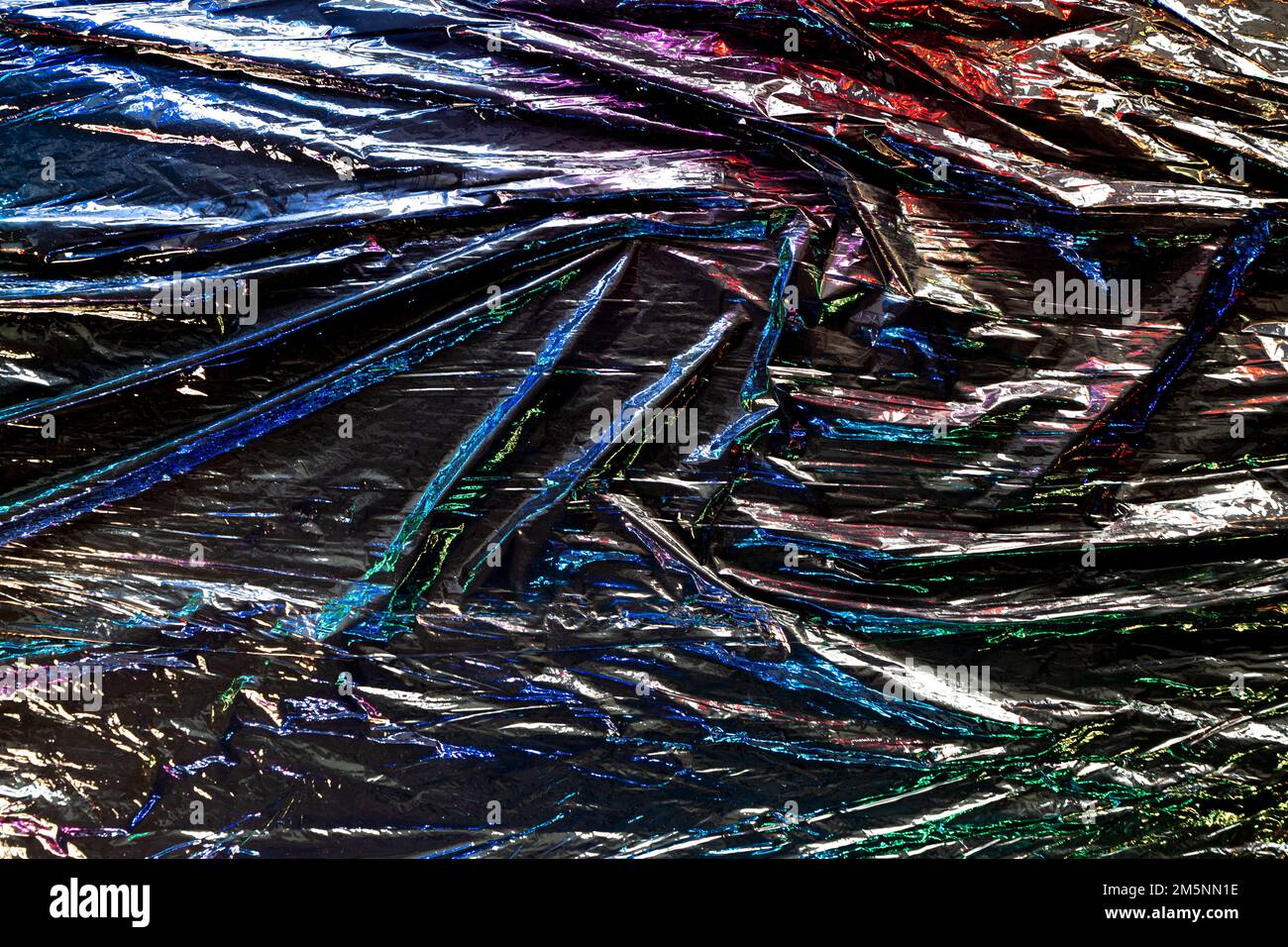 Black color plastic wrap background. Dark crumpled wrinkled plastic