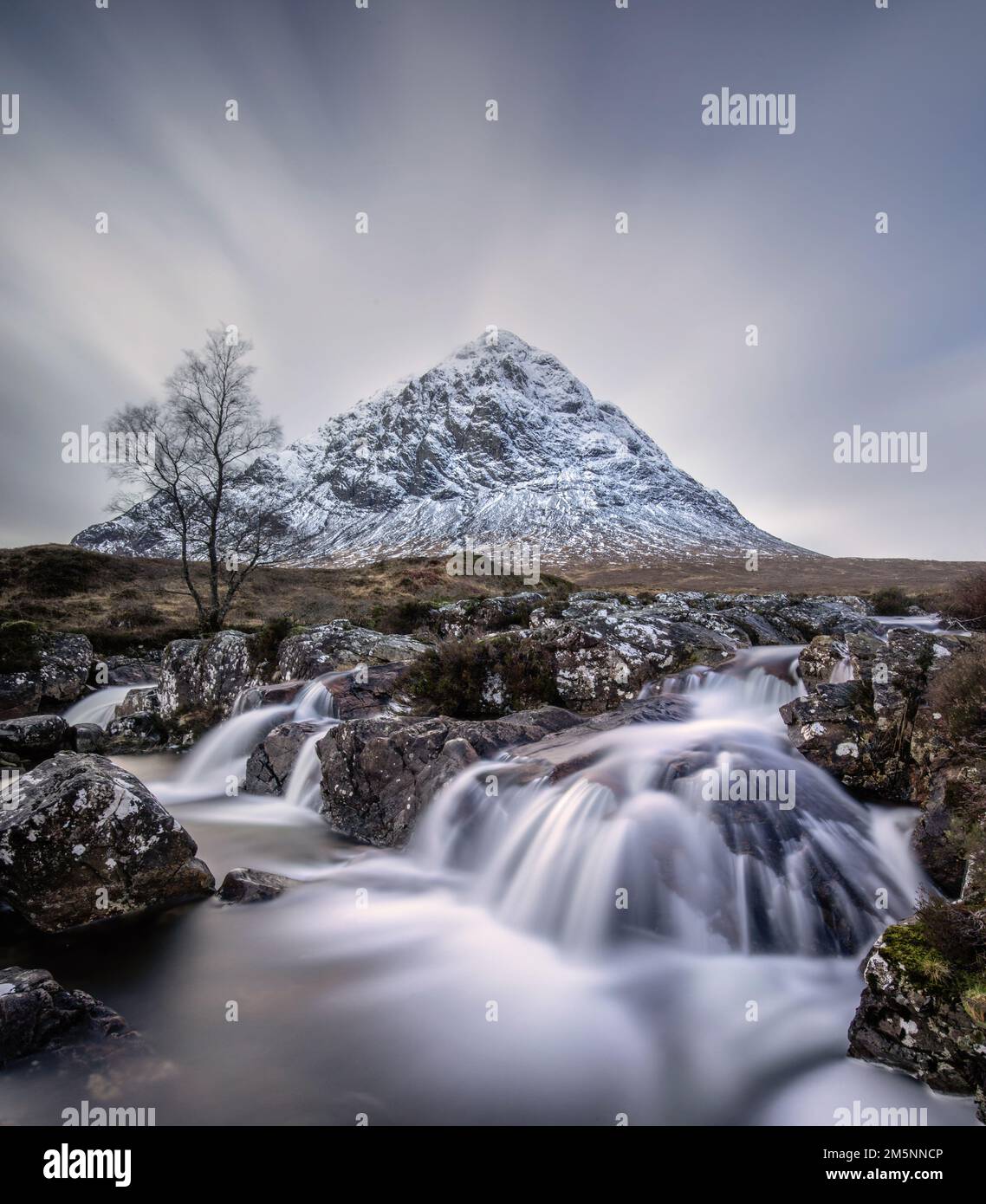 Glencoe waterfall and snow covered mountain in the Scottish Highlands. Rugged scenery and landscapes in the mountains near Loch Ness and Fort William. Stock Photo
