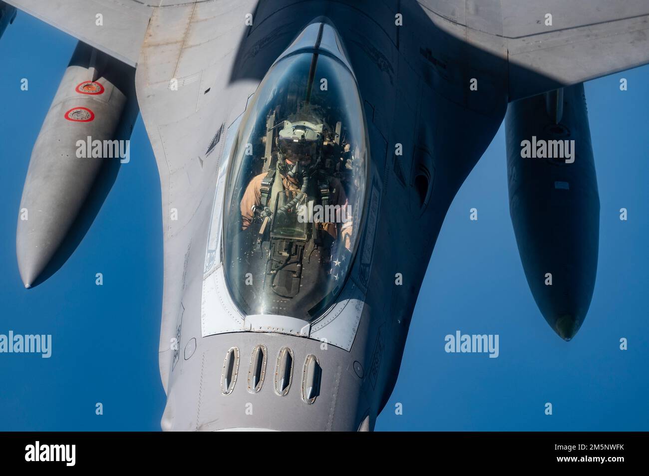 A U.S. Air Force F-16 Fighting Falcon assigned to the 332d Air Expeditionary Wing conducts aerial refueling with a U.S. Air Force KC-135 Stratotanker assigned to the 28th Expeditionary Air Refueling Squadron above the Arabian Gulf, Feb. 26, 2022. The 28th EARS, deployed with U.S. Air Forces Central, conducted aerial refueling with six U.S. fighter aircraft in support of an exercise with a partner nation. Stock Photo