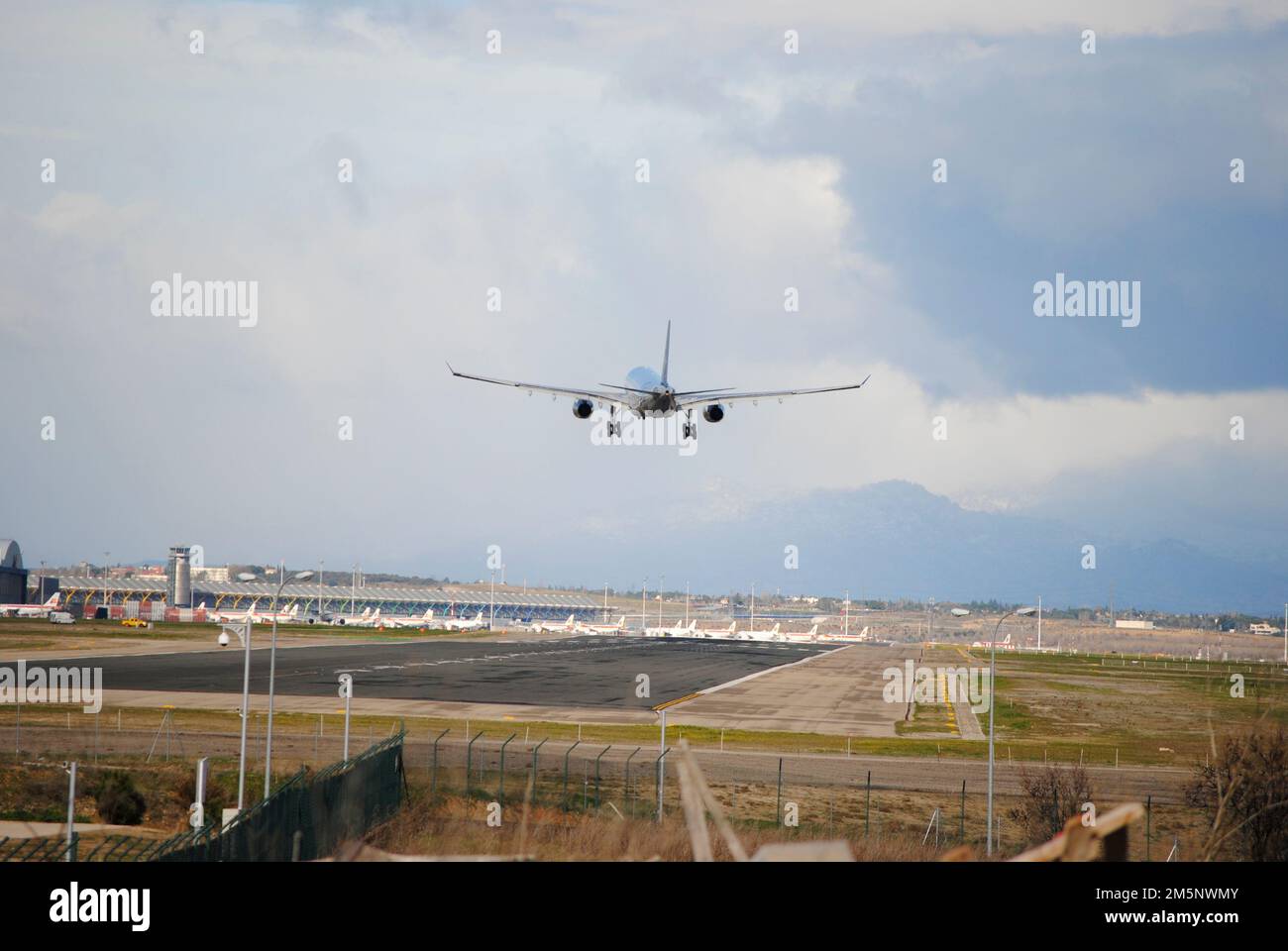 A flight taking off and flying over the Airport Runway under blue sky ...