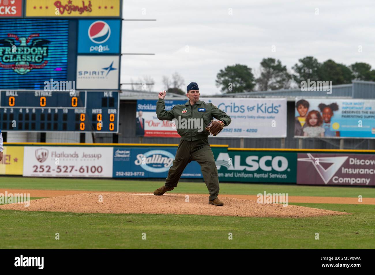 Col. Bryce Silver, 4th Fighter Wing vice commander, throws the first pitch during the 12th Annual Freedom Classic baseball series at Grainger Stadium in Kinston, North Carolina, Feb. 26, 2022. The first pitch is a long-standing tradition of baseball, in which a guest of honor throws a ball to mark the end of pregame festivities and the start of the game. Stock Photo
