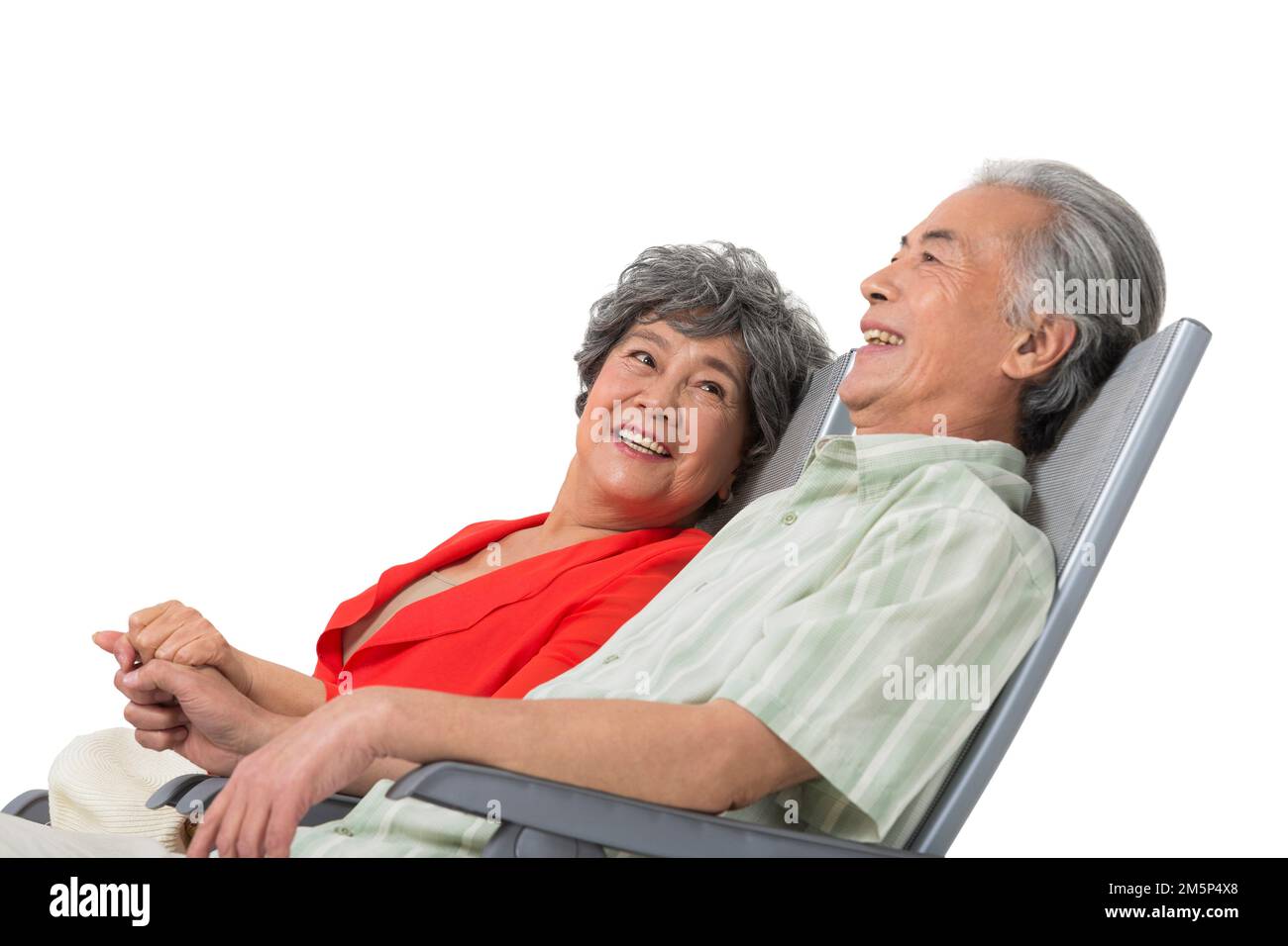 Happy elderly couple sitting on a beach chair Stock Photo - Alamy