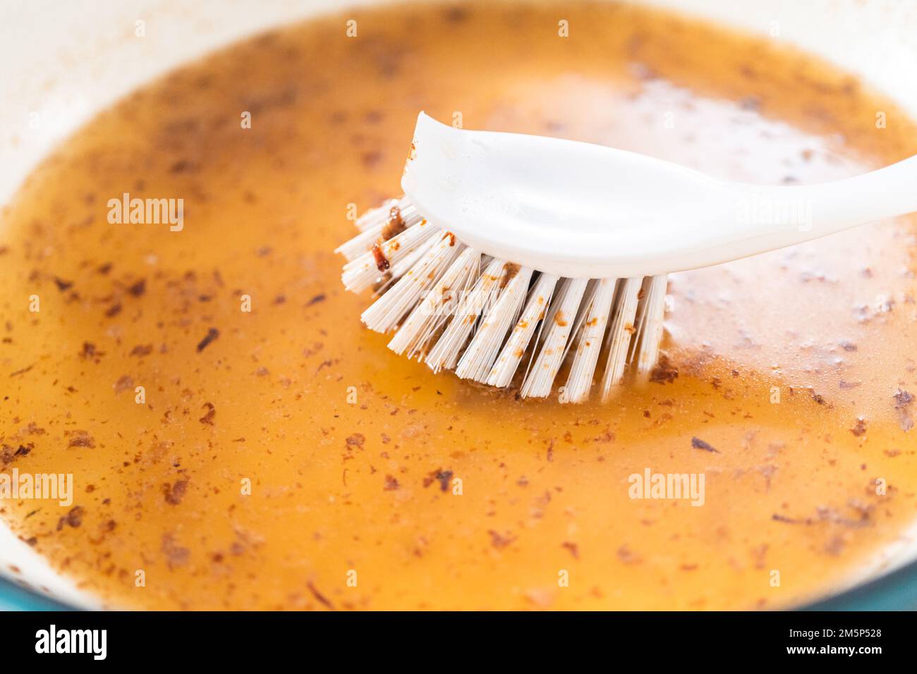 Cleaning cast iron blue enameled braiser Stock Photo - Alamy