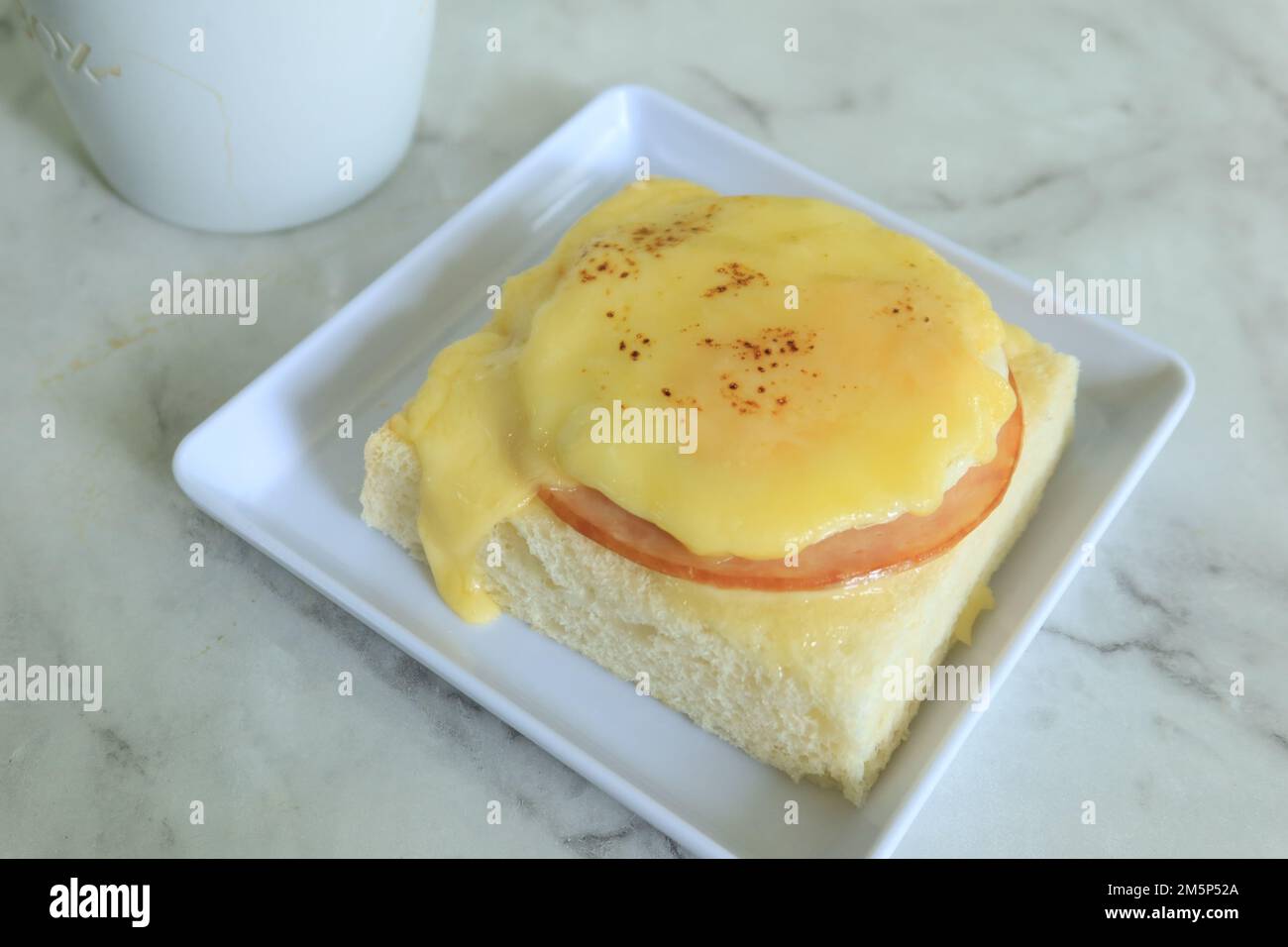cured ham, egg and bread and cup of tea on table  Stock Photo
