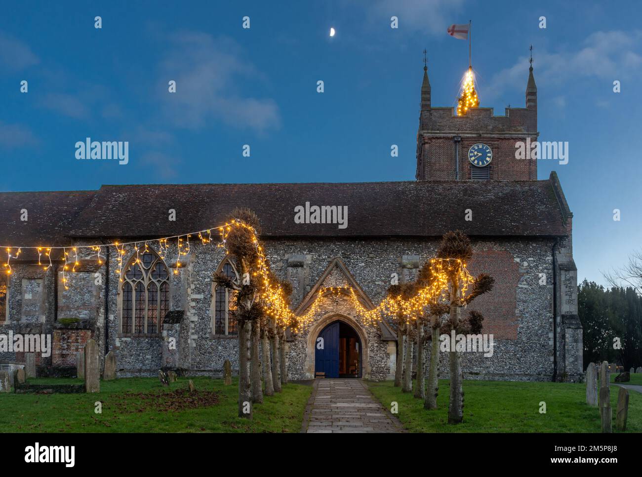 Christmas lights and tree at All Saints Parish Church in Odiham village, Hampshire, England, UK Stock Photo