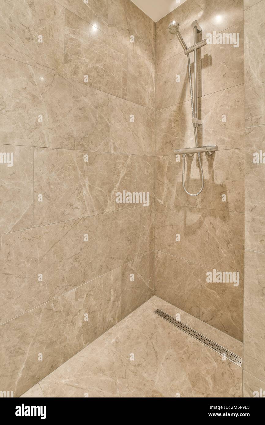 a bathroom with marble walls and shower head mounted to the wall, it's