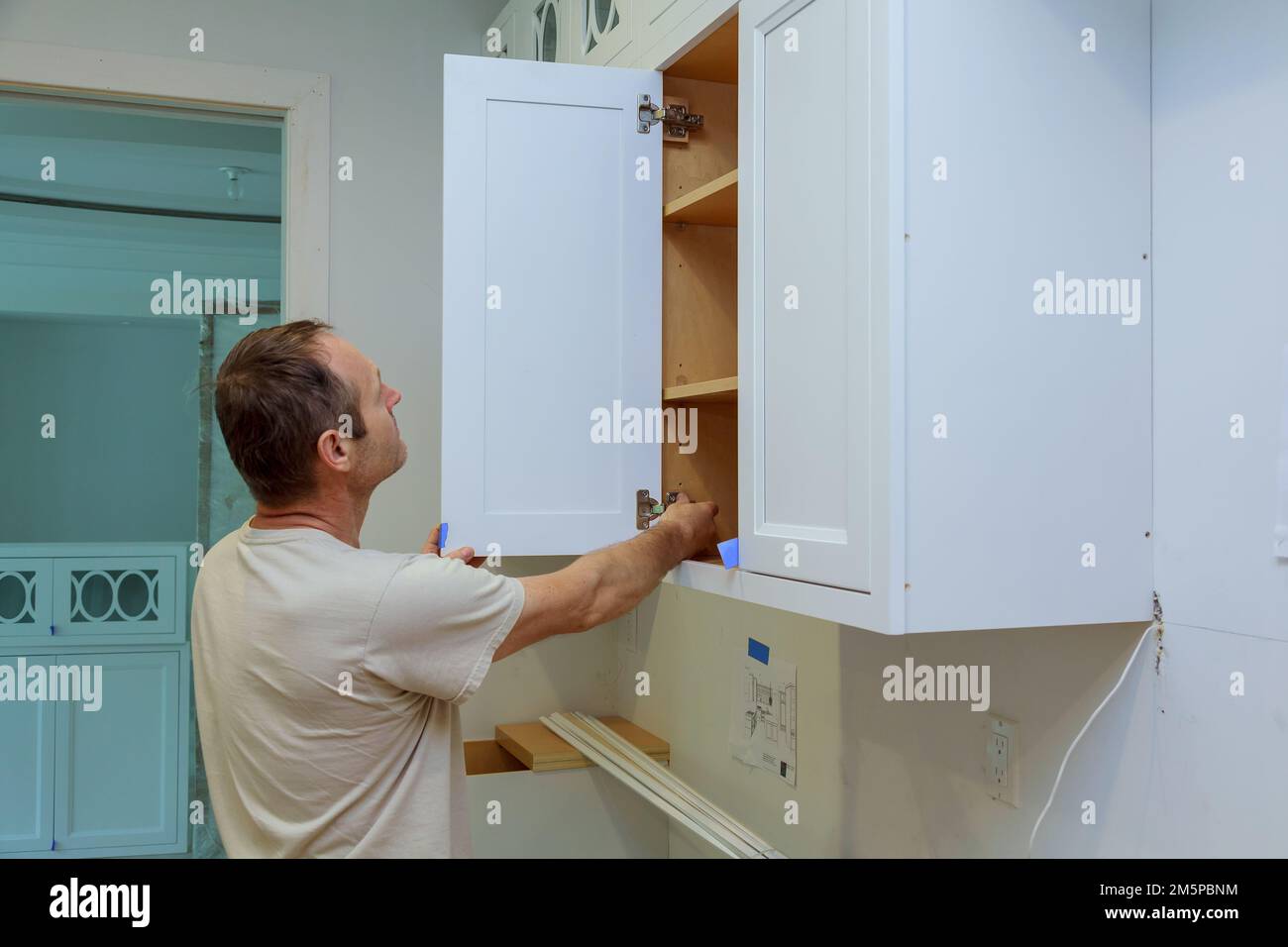 In new home carpenter is fixing door to kitchen Stock Photo Alamy