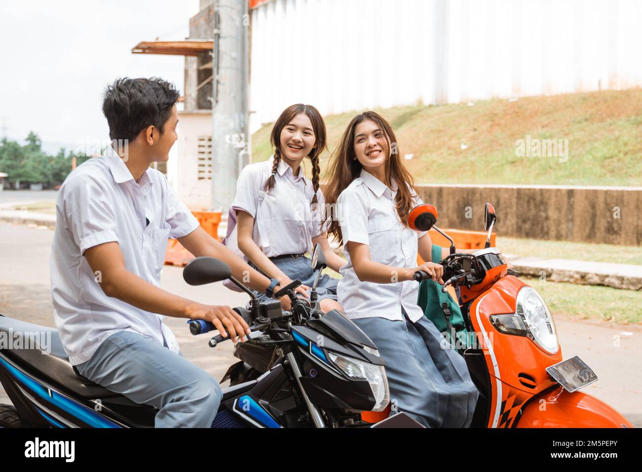 High school student delinquent girl riding motorbike greets male