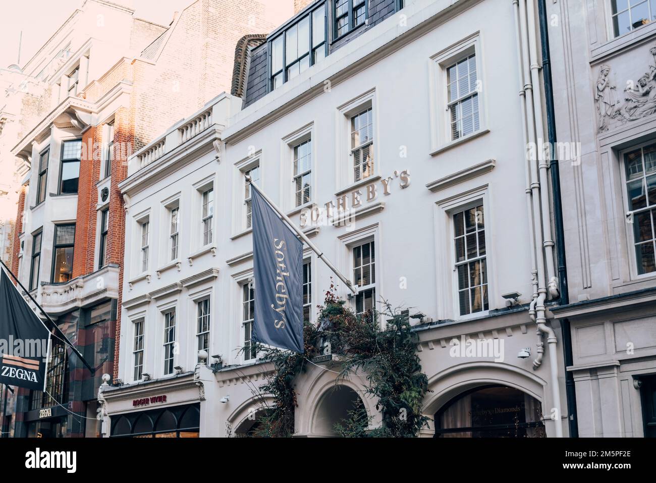 London, UK - December 26, 2022: Name and flag on the building of Sotheby's, one of the world's largest brokers of fine and decorative art, jewellery, Stock Photo