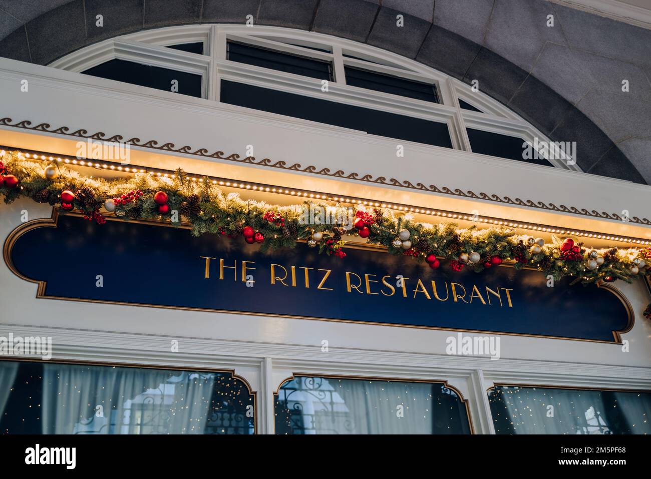 London, UK - December 26, 2022: Festive decorated sign outside The Ritz Restaurant, high-end British–French dining in baroque-style gilded salon with Stock Photo