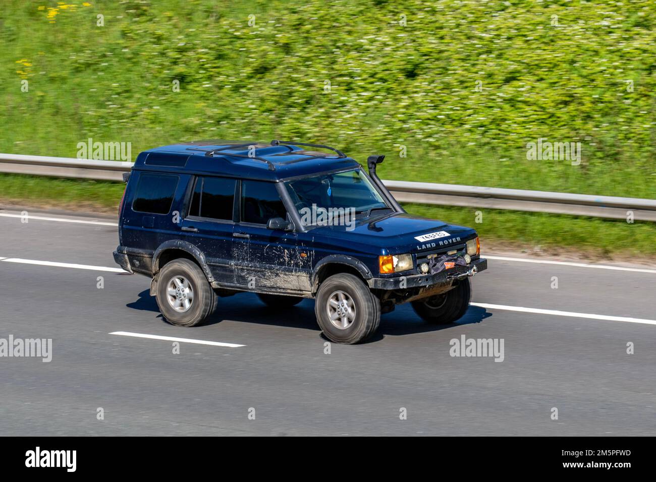 2001 Black LAND ROVER DISCOVERY Muddy 2495cc Diesel 4x4 off-road SUV vehicle with snorkel exhaust; travelling on the M6 Motorway UK Stock Photo