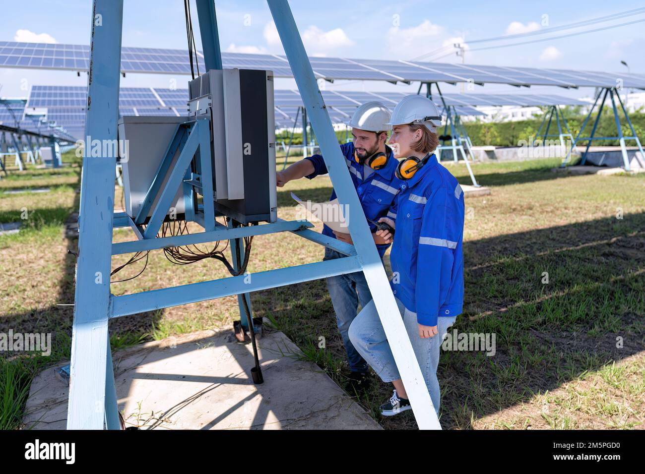 Maintenance engineer at solar farm trouble shooting looking at inverter
