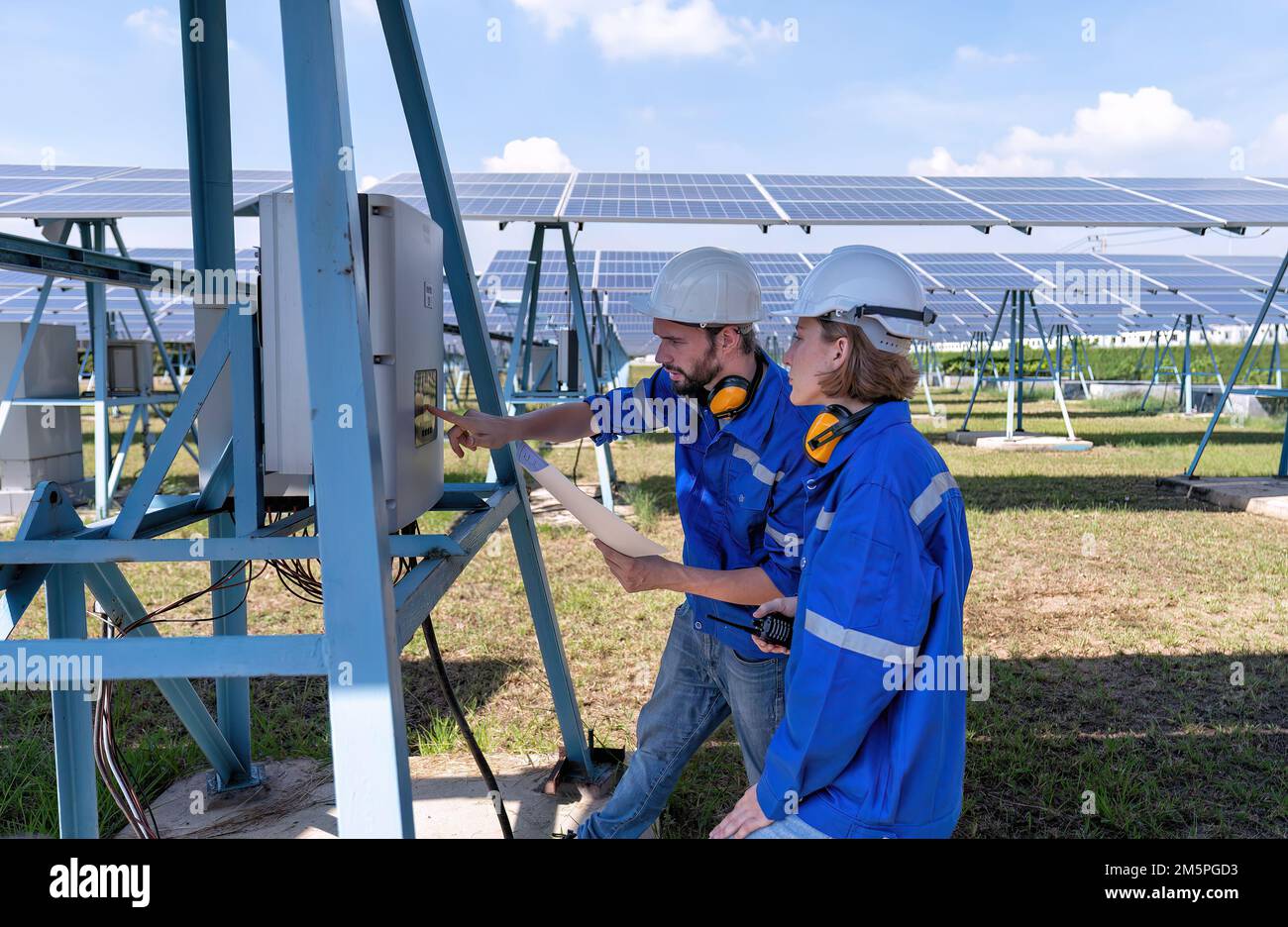 Maintenance engineer at solar farm trouble shooting looking at inverter