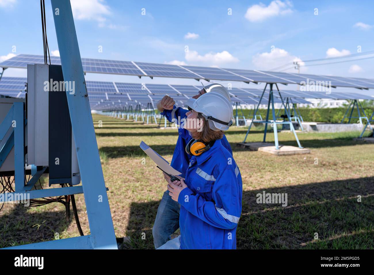 Maintenance engineer at solar farm trouble shooting looking at inverter