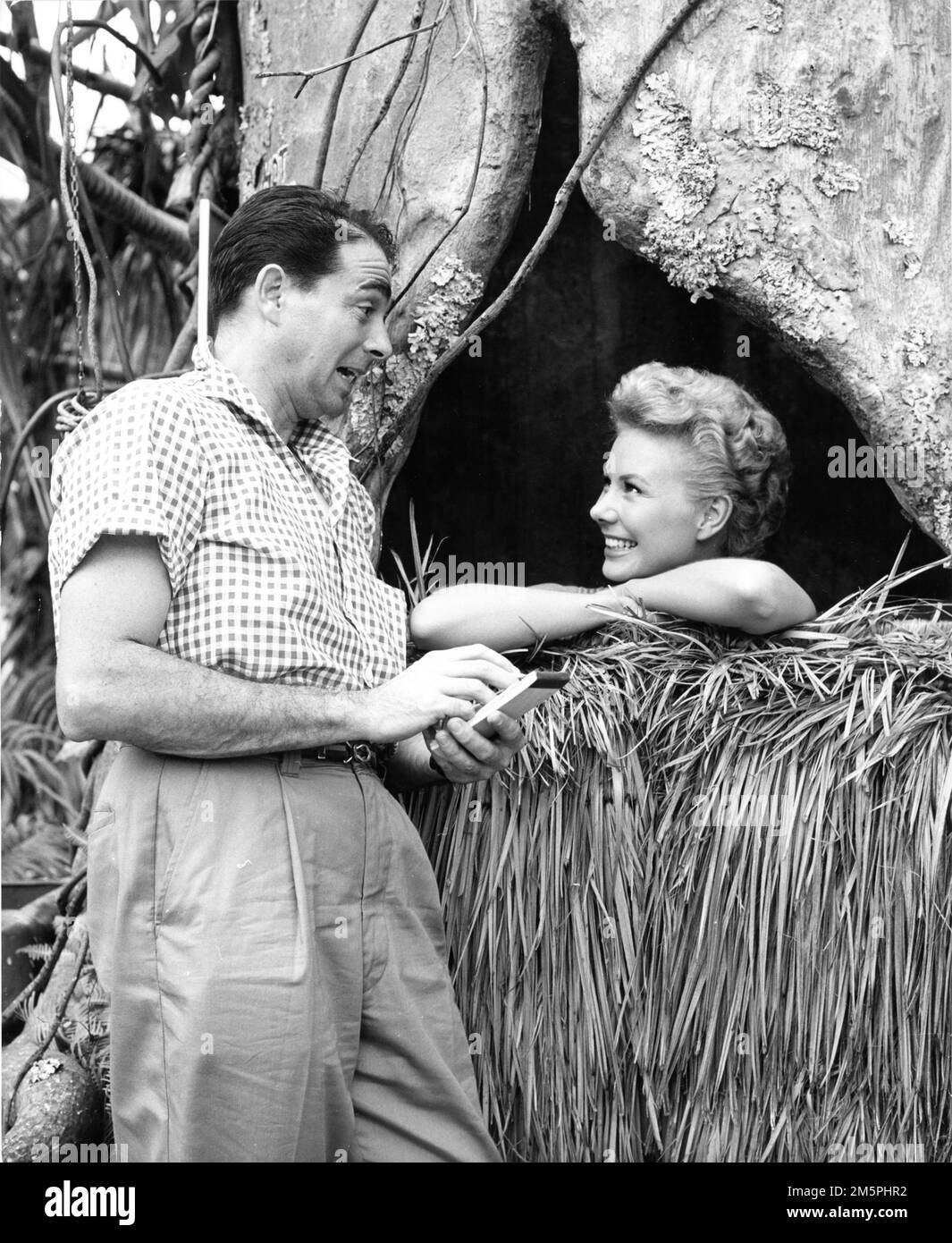 MITZI GAYNOR on set candid with Variety columnist ARMAND ''ARMY'' ARCHERD during filming of RODGERS and HAMMERSTEIN's SOUTH PACIFIC 1958 director JOSHUA LOGAN music Richard Rodgers lyrics Oscar Hammerstein II based on Tales of the South Pacific by James A. Michener Rodgers and Hammerstein Productions / Magna Theatre Corporation / Twentieth Century Fox Stock Photo