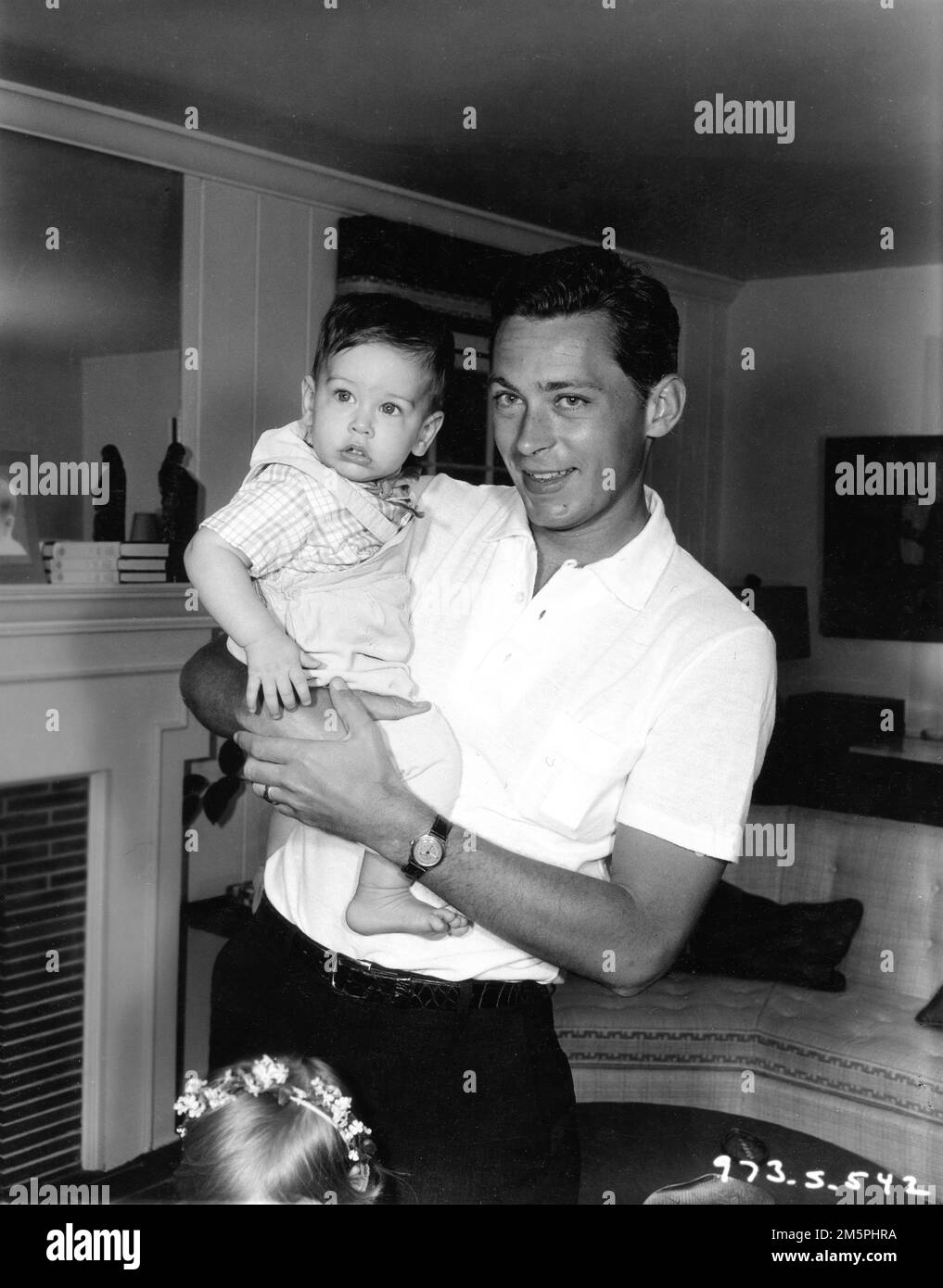 JOHN KERR at home with his baby son publicity for RODGERS and HAMMERSTEIN's SOUTH PACIFIC 1958 director JOSHUA LOGAN music Richard Rodgers lyrics Oscar Hammerstein II based on Tales of the South Pacific by James A. Michener Rodgers and Hammerstein Productions / Magna Theatre Corporation / Twentieth Century Fox Stock Photo