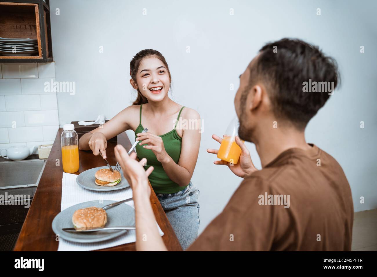 attractive young girl chatting with young man at breakfast Stock Photo